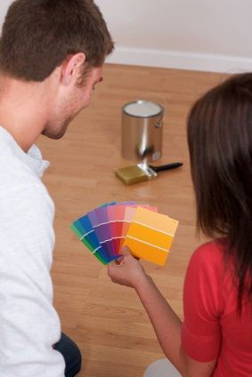Couple selecting paint color for painters to begin painting their house.